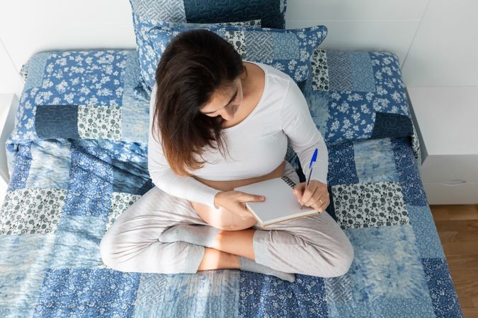 Pregnant woman taking notes in notepad