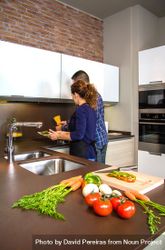 Couple cutting vegetables in the kitchen to prepare food beWOq5