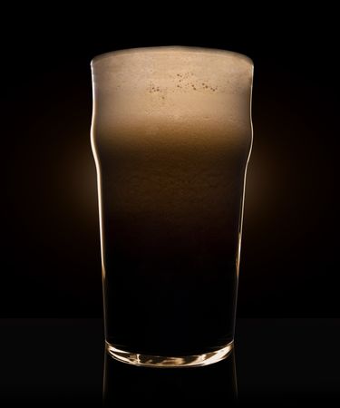 Glass of beer with heavy dark foam