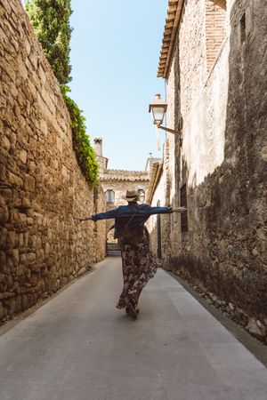 Woman walking in a narrow path in a village