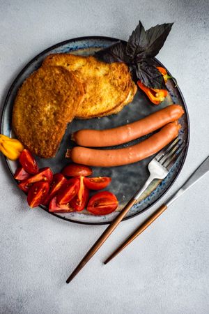 Top view of sausage dinner with tomatoes on a plate
