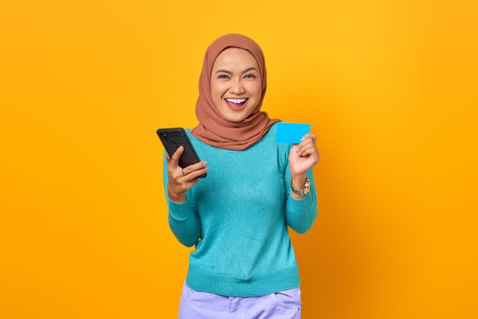 Muslim woman smiling with phone in her hand