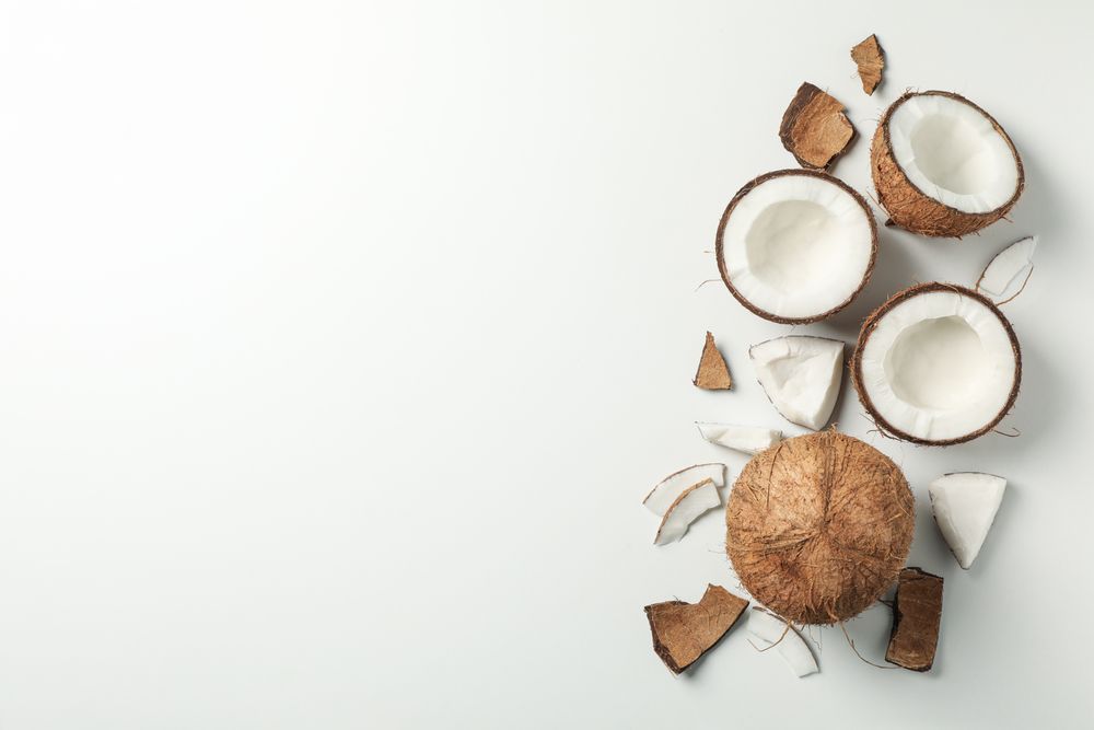 Coconut on plain background, top view and space for text