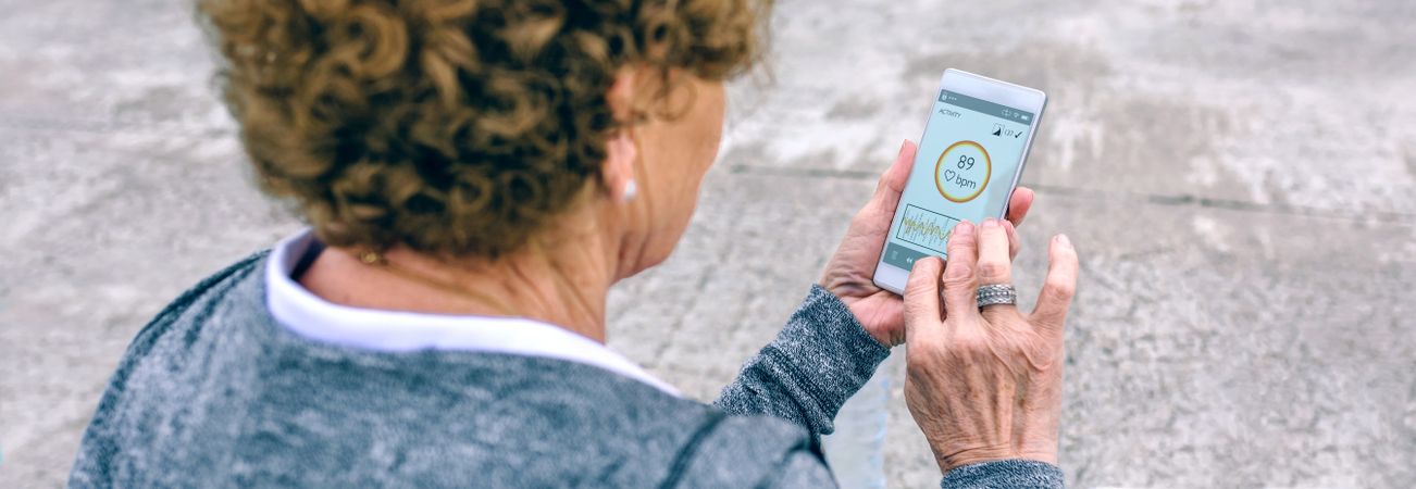 Back view of Older woman using smartphone