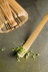 Green matcha tea powder and bamboo whisk