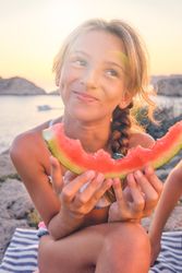 Happy girl with watermelon slice on beach