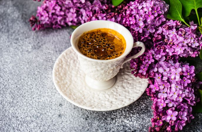 Spring floral card concept with top view of espresso with lilacs