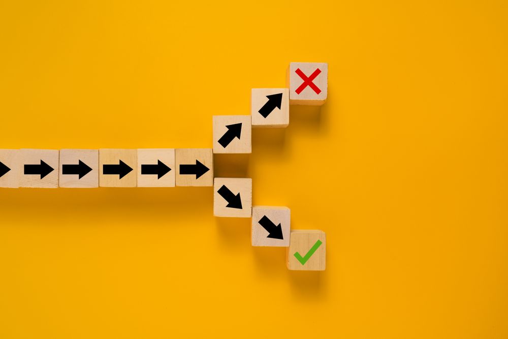 arrow symbol on wooden blocks splitting into right and wrong direction. concept of choosing right or wrong way