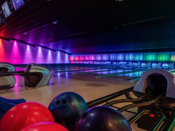 Multi-colored illumination of lanes in a huge bowling alley.