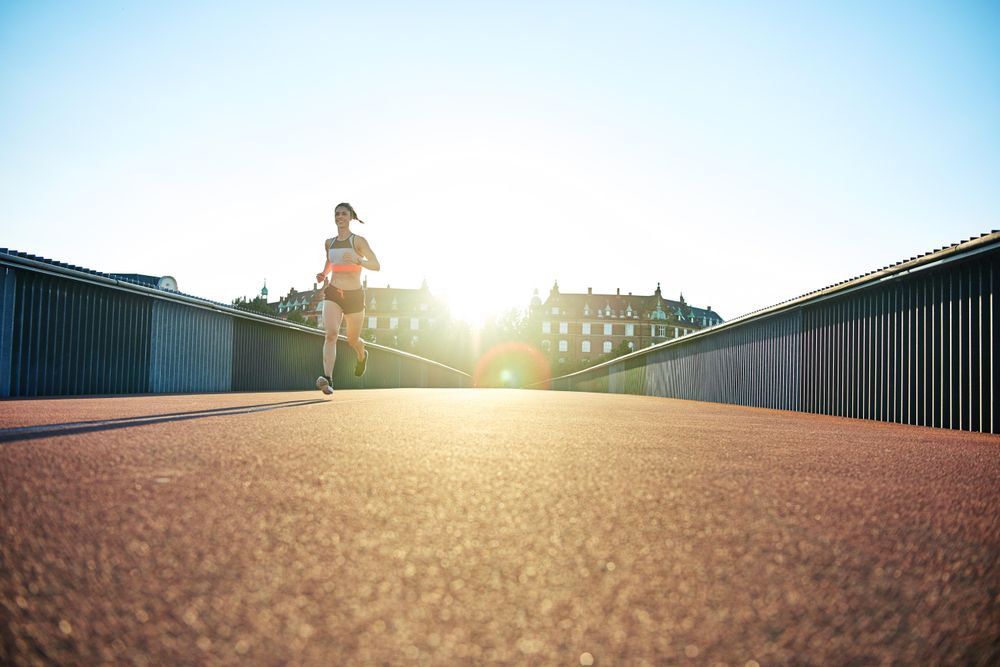 Bright European bridge with female jogger