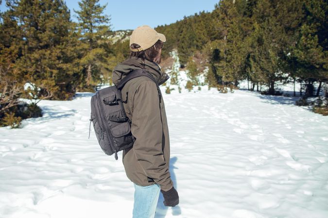 Man between winter forest in sunny day