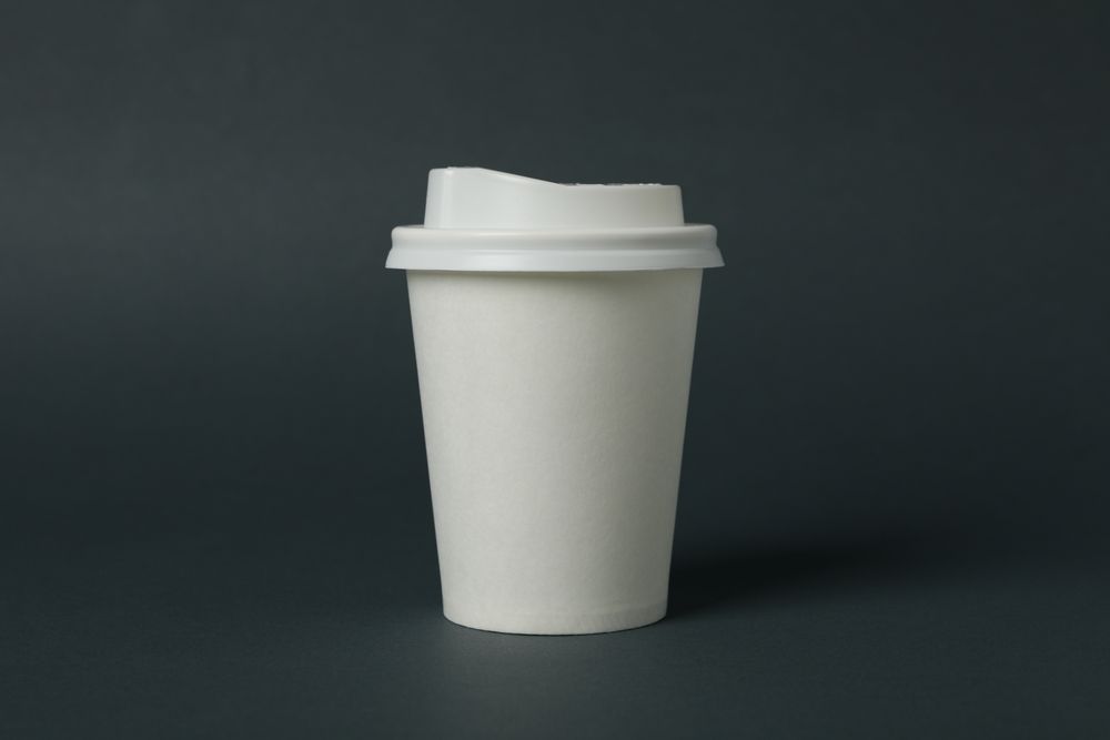 paper cup on light dark background, space for text