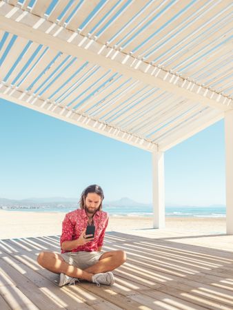 Man using smartphone on beach