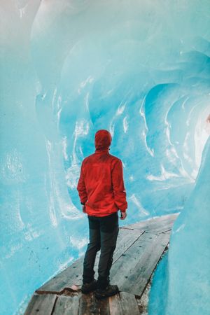 Man in red hoodie standing in ice cave