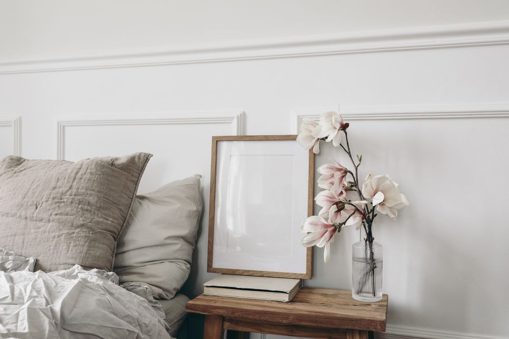 Empty vertical wooden picture frame mockup, old books