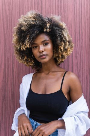 Stylish Black woman standing near colorful door