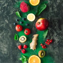 Fruits, vegetables and leaves on dark stone table background