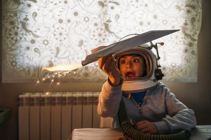 Dreamy kid having fun with toy airplane