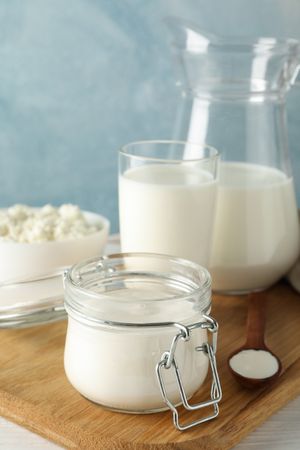 Fresh dairy products on plain wooden table, copy space