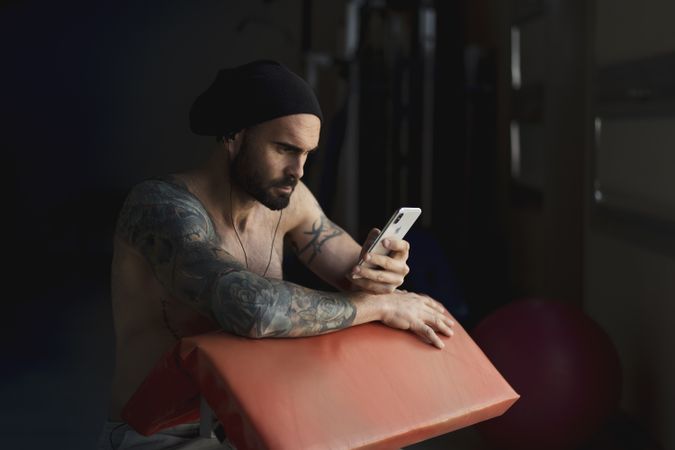 Athlete with smartphone in gym