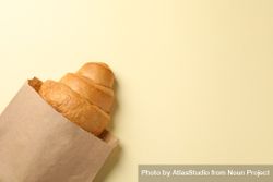 Craft paper bag with croissant on beige background, space for text 5aadW5