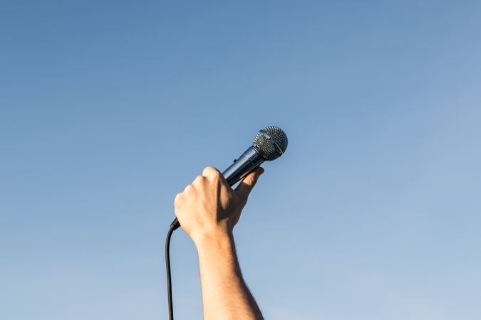 man hand holding a microphone