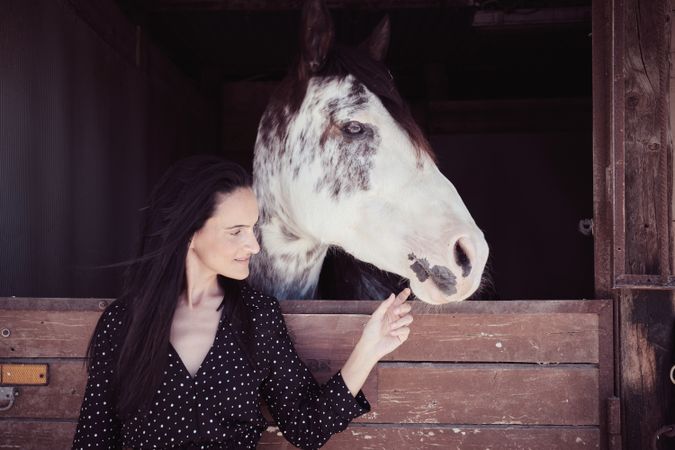 Woman touching muzzle of horse
