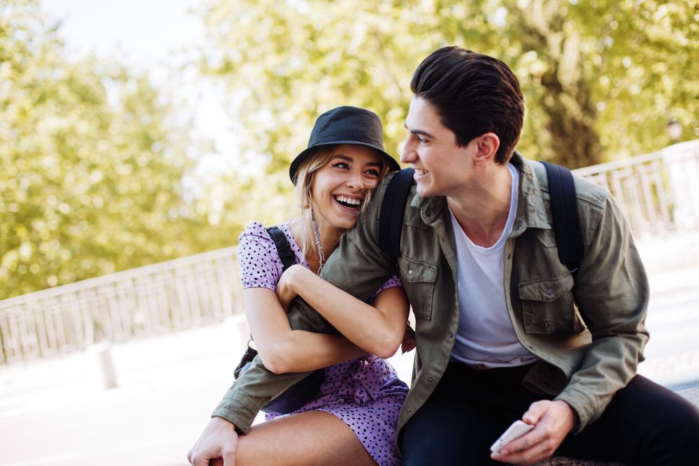 Happy couple having fun sitting in the street