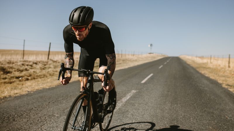 Sportsman cycling on long road