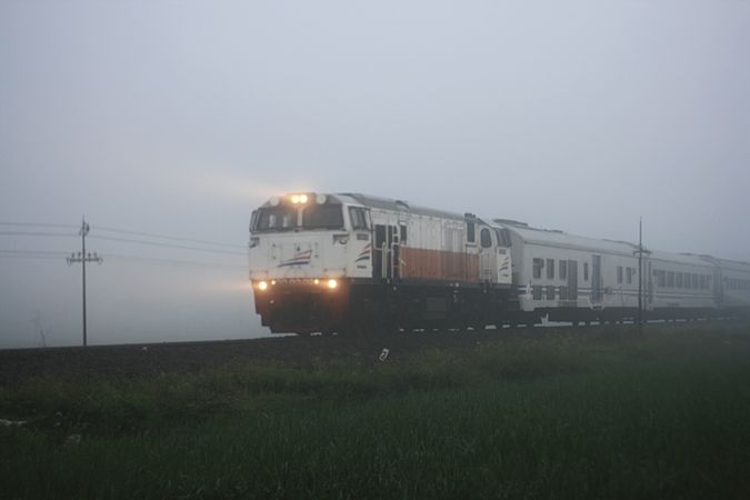 Train with headlights on misty day