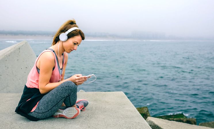 Sportswoman with headphones sitting