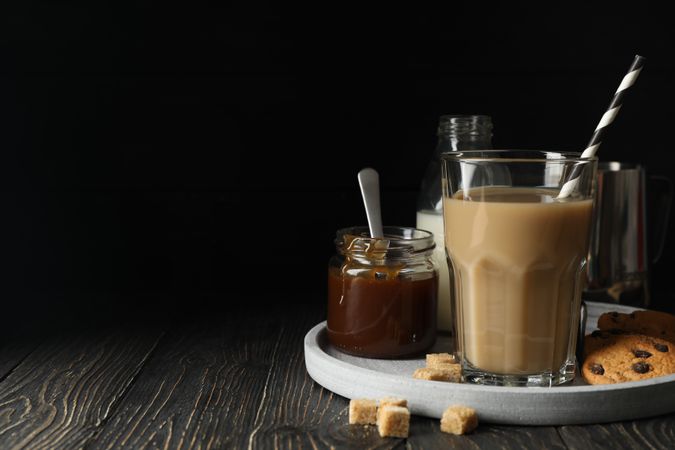 Composition with ice coffee and cookies on wooden background