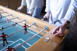 A young man is taking a euro coin to be used in the table football game