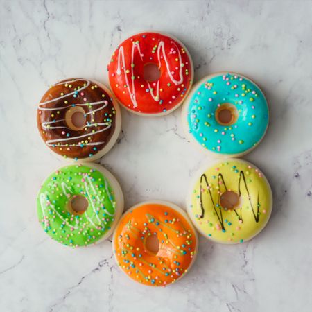 Circle of colorful donuts on marble background