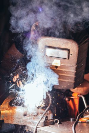 Professional welder in mask welding metal