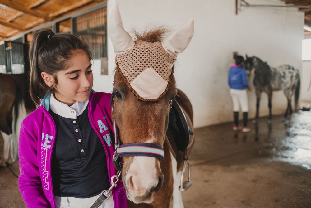 Girl with adorable pony in hat