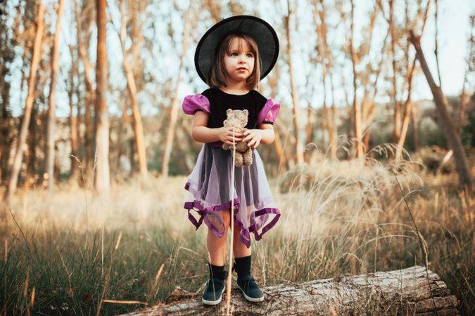 Young girl in witch costume in the forest
