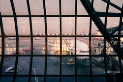 Airplane at gate viewed through large window with panes at airport