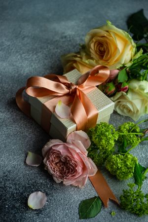 Pastel flowers on grey counter with present
