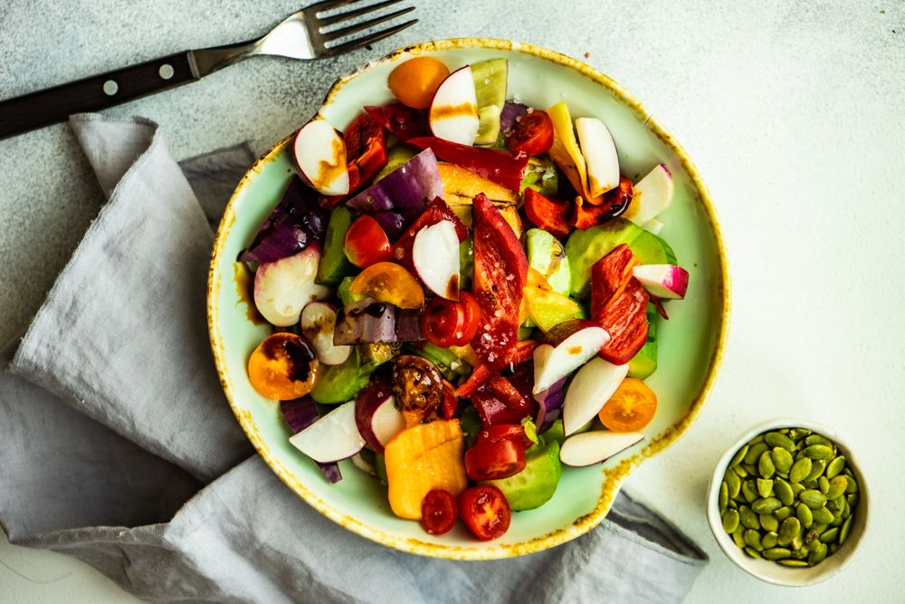 Top view of raw salad with freshly chopped vegetables in bowl