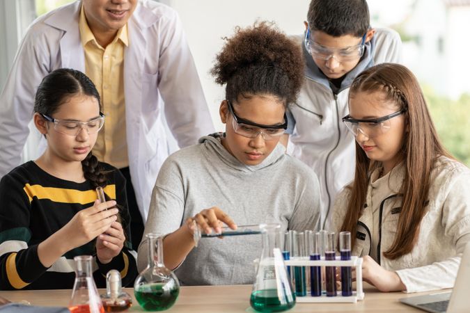 Multi-ethnic students and teacher in science class doing experiment