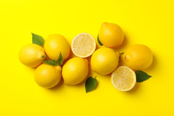 Lemons on yellow background, top view. Fresh fruit