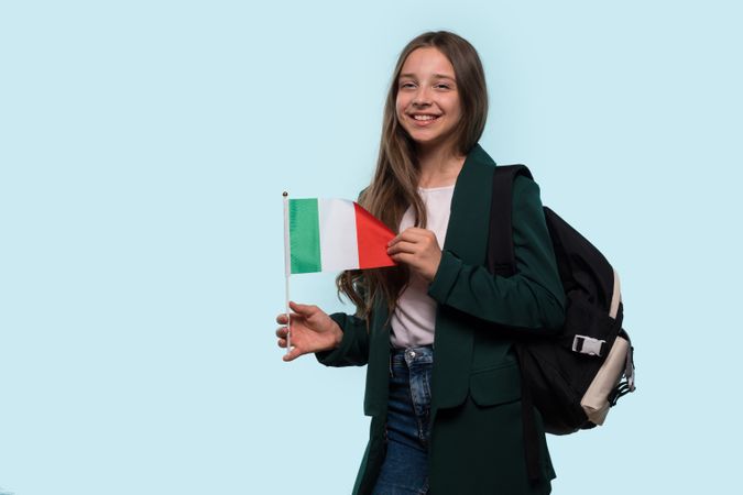 Teen girl holding Italian flag, casual look.
