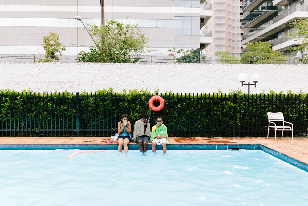 Young people dipping their legs into swimming pool