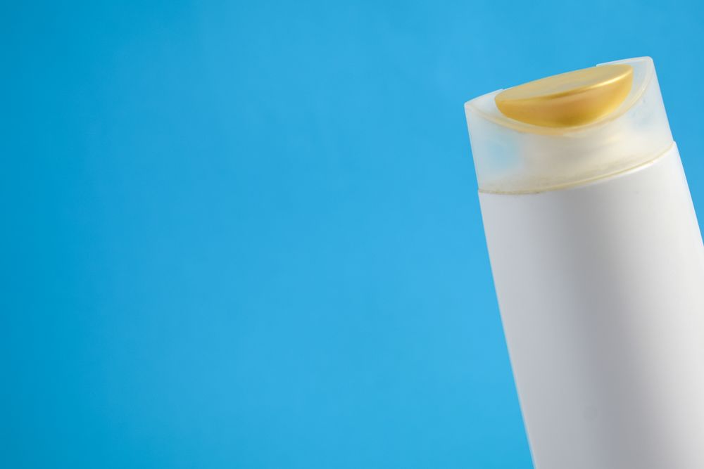 Bottle of body wash or shampoo against blue background