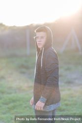 Teenage male in hoodie standing in field 48pZJ4