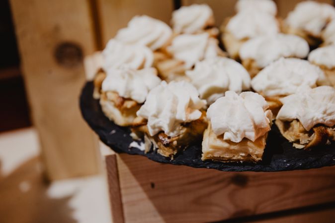 Tasty desserts on plate on wooden stand