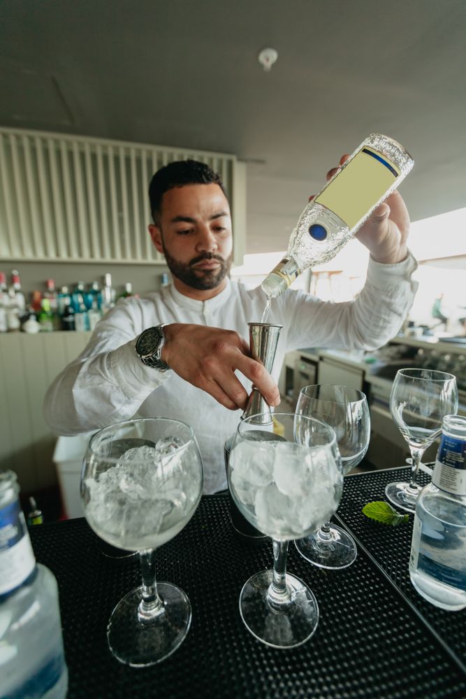 Cheerful Barman preparing alcoholic drinks in a bar.