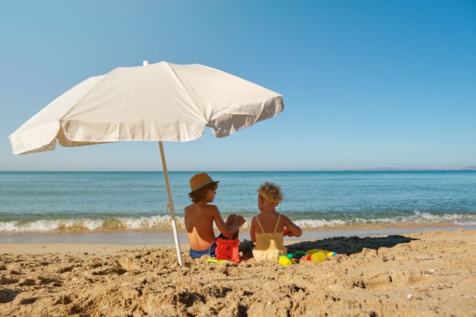Little boy and girl sitting on beach