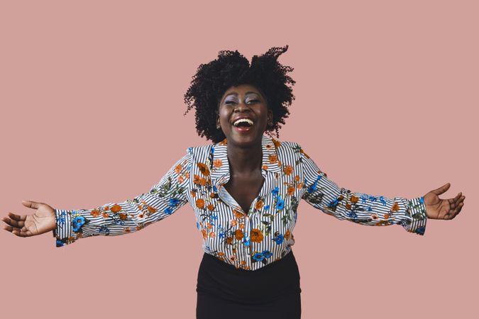Portrait of happy Black woman with her arms outstretched